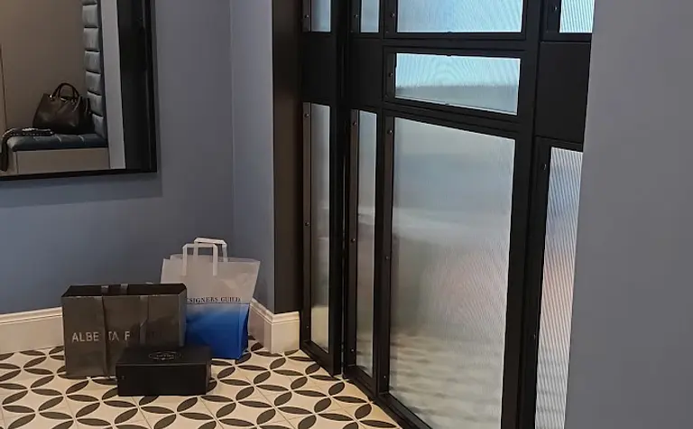 Przedpokój z niebieskimi ścianami, lustrzanym odbiciem i elegancką podłogą w stylu glamour.