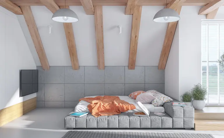 Poddasze z szarymi ścianami i drewnianymi belkami, nowoczesne i skandynawskie.