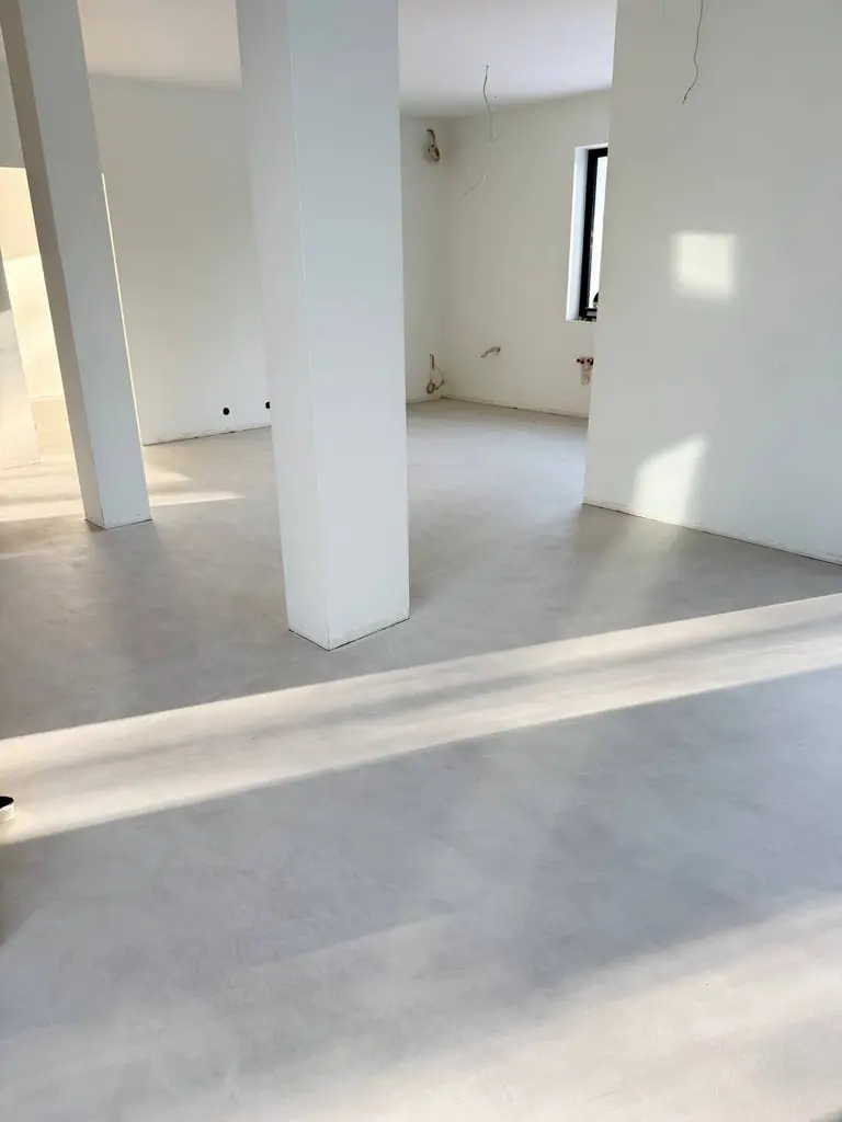 Przestronny pokój z białymi ścianami, szarym podłogą, w stylu art deco i minimalistycznym.