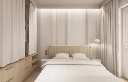 Minimalistyczna sypialnia w stylu japandi z jasnymi meblami i subtelnym oświetleniem.