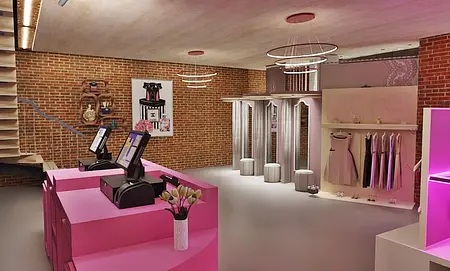 Wnętrze sklepu odzieżowego w stylu nowoczesnym i quiet luxury z różowymi detalami.