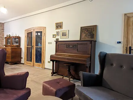 Wnętrze salonu w stylu boho i rustykalnym z fortepianem i drewnianymi meblami
