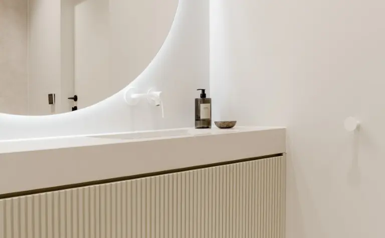 Minimalistyczna łazienka z białą umywalką i drewnianymi akcentami, styl japandi i soft minimalizm