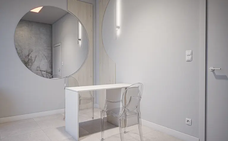 Minimalistyczne wnętrze z biurkiem, przezroczystymi krzesłami i dużym lustrem.