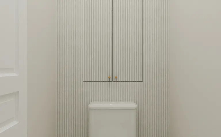 Toaleta w stylu art deco z białą ceramiką i mozaiką.