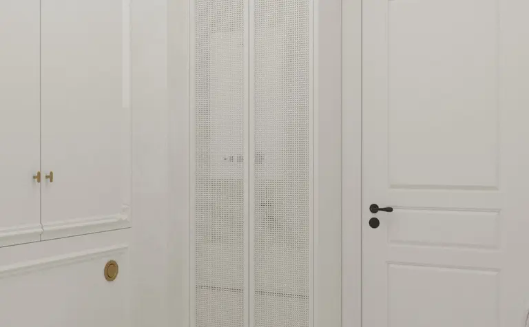 Wnętrze łazienki z białymi meblami, podłogą art deco oraz tradycyjnymi detalami.