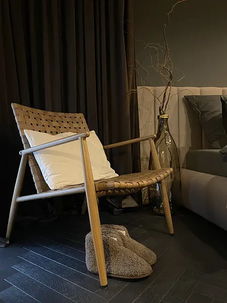 Wnętrze eklektyczne z brązowym fotelem i dekoracjami.