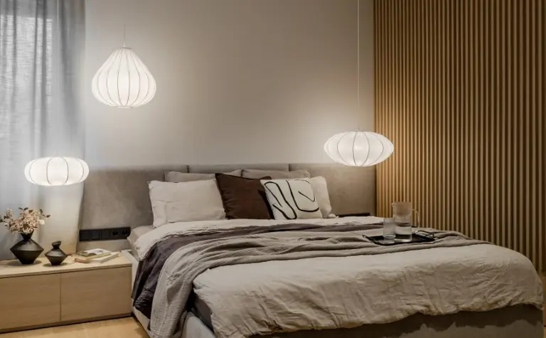 Sypialnia w stylu japandi z minimalistycznym wystrojem, strefą relaksu i oświetleniem.