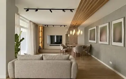 Nowoczesne wnętrze salonu z beżową sofą i drewnianym stołem