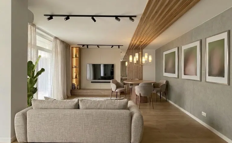 Nowoczesne wnętrze salonu z beżową sofą i drewnianym stołem