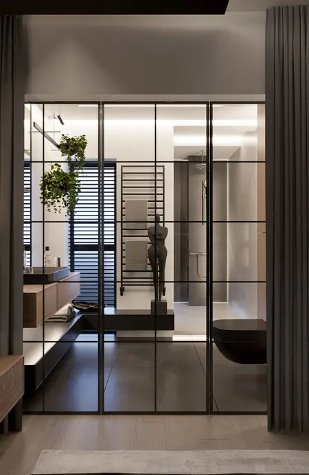 Nowoczesna łazienka z czarną wanną, minimalistycznym wystrojem i praktycznymi detalami