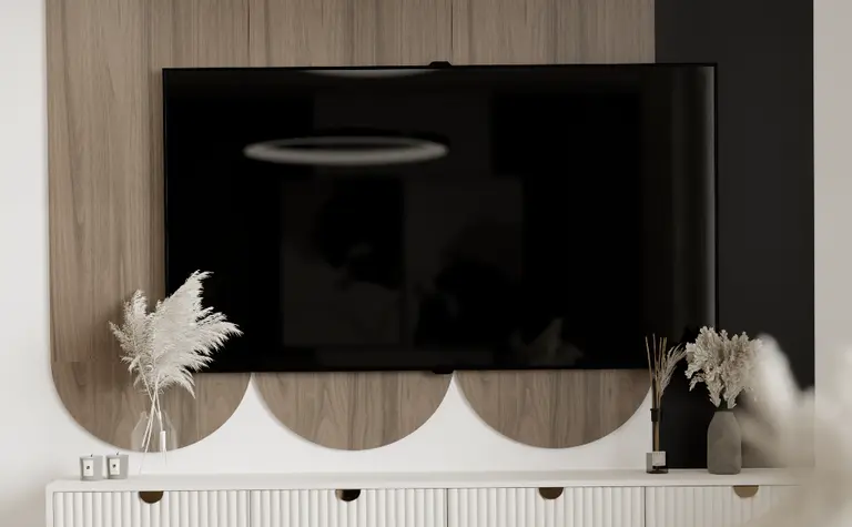 Wnętrze nowoczesnego salonu z telewizorem i drewnianą komodą.