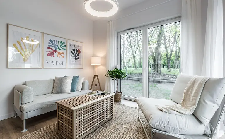 Wnętrze salonu w stylu skandynawskim z jasnymi meblami i rośliną
