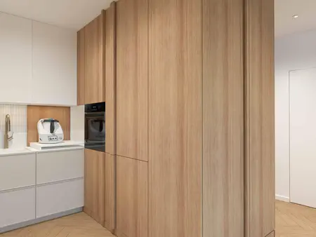 Kuchnia japandi z drewnianymi szafkami i minimalistycznym designem.