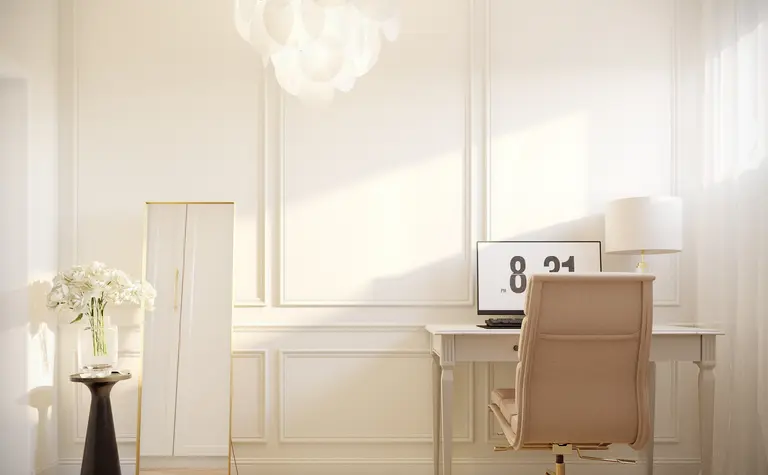 Wnętrze gabinetu z białym biurkiem, lustrem i jasnym oświetleniem w stylu quiet luxury.