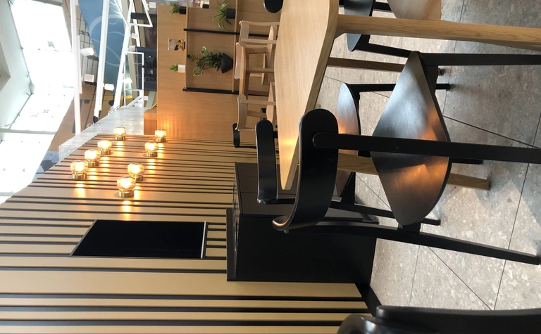 Wnętrze kawiarni w stylu japandi, minimalistycznym i nowoczesnym z drewnianymi detalami.