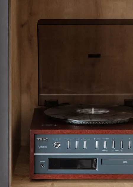 Gramofon TEAC na drewnianej półce w minimalistycznym, nowoczesnym wnętrzu.