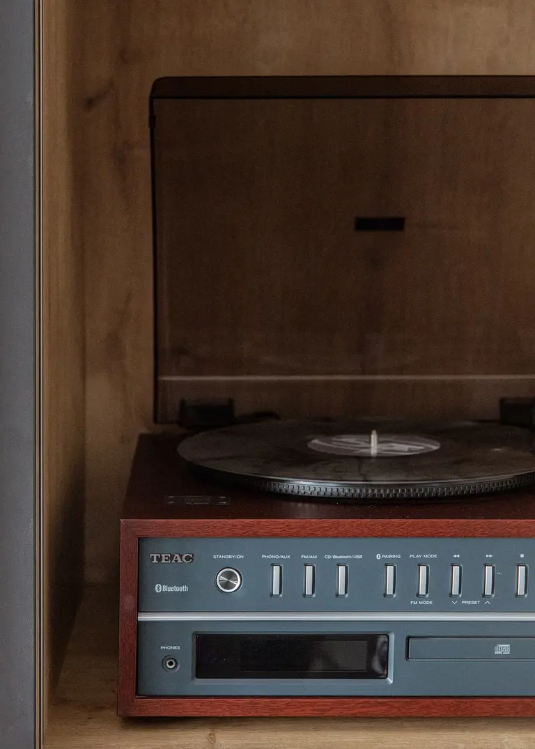 Gramofon TEAC na drewnianej półce w minimalistycznym, nowoczesnym wnętrzu.
