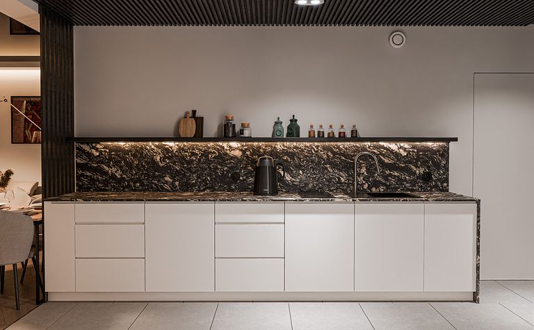 Nowoczesna kuchnia z białymi meblami i czarnym blatem, minimalistyczny projekt.