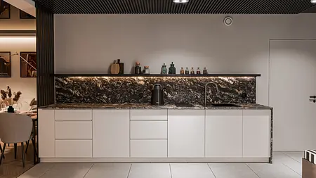 Nowoczesna kuchnia z białymi meblami i czarnym blatem, minimalistyczny projekt.