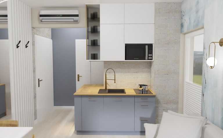 Wnętrze kuchni z szarymi meblami i drewnianym blatem, minimalistyczny design.