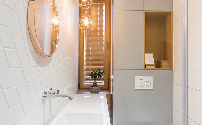 Wnętrze łazienki w stylu industrialnym i minimalistycznym z białymi elementami.