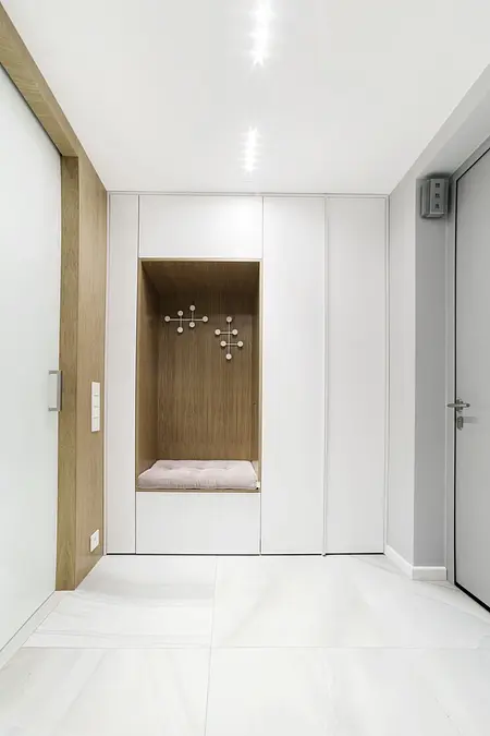 Przedpokój z minimalistycznym designem, nowoczesnymi elementami i drewnianymi akcentami.
