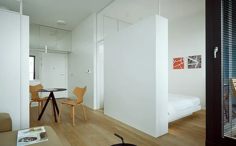 Minimalistyczne wnętrze z białymi ścianami i drewnianymi meblami, styl minimaluxe.