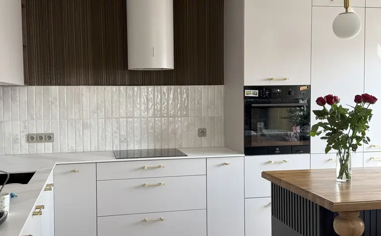 Nowoczesna kuchnia w stylu eklektycznym z białymi meblami i drewnianymi detalami.