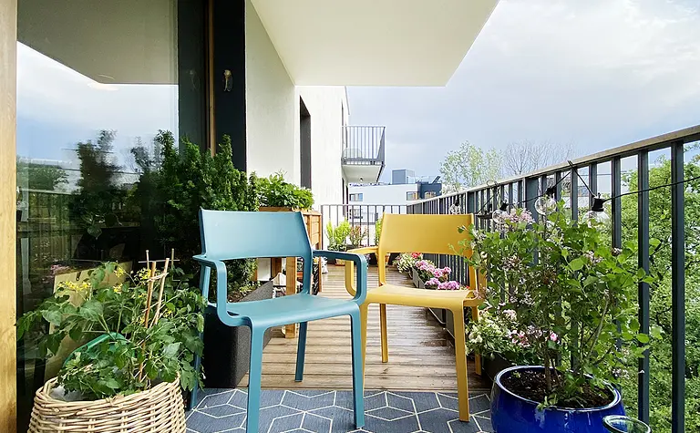 Balkon z minimalistycznymi meblami i zielenią, nowoczesny styl dekoracji.