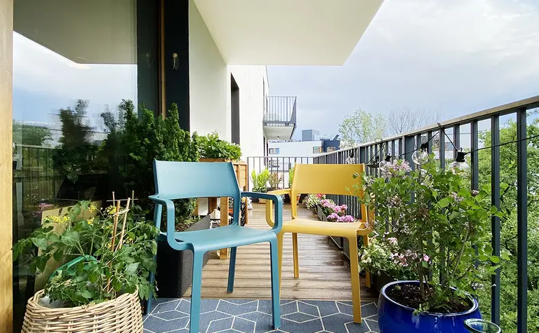 Balkon z minimalistycznymi meblami i zielenią, nowoczesny styl dekoracji.