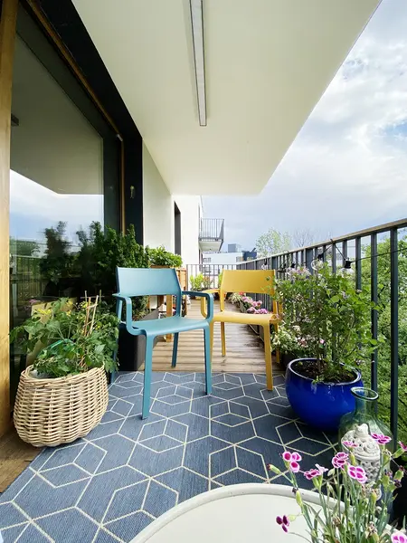 Balkon z minimalistycznymi meblami i zielenią, nowoczesny styl dekoracji.