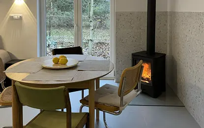 Jadalnia w stylu boho, minimalistycznym i rustykalnym z drewnianym stołem i kominkiem.