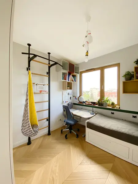 Minimalistyczny pokój z biurkiem, łóżkiem i regałem w nowoczesnym stylu.
