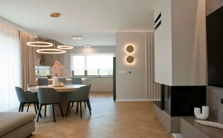Jadalnia z okrągłym stolikiem, szarymi krzesłami, minimalistyczny styl, nowoczesny design.