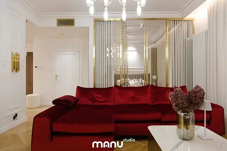 Wnętrze salonu z nowoczesną czerwoną sofą, białym stolikiem oraz elementami quiet luxury.