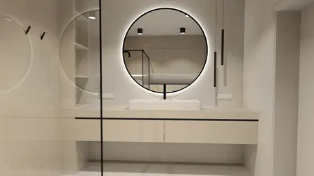 Wnętrze łazienki z okrągłym lustrem, minimalistycznym blatem oraz płytkami w stylu boho i japandi.