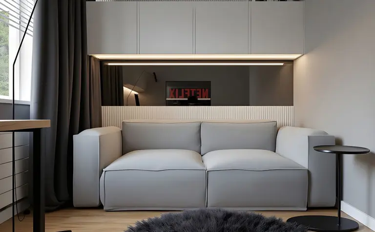 Minimalistyczne wnętrze z szaro-skalną sofą i czarnymi akcentami.