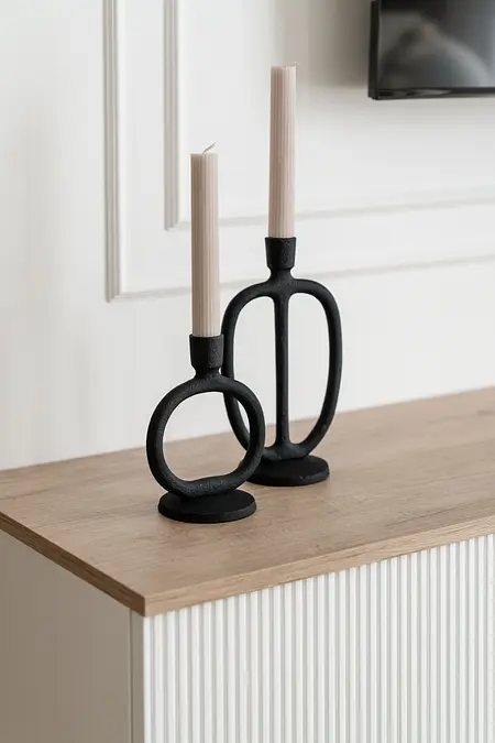 Świeczniki na drewnianym blacie w nowoczesnym wnętrzu.