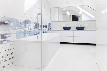 Wnętrze salonu z minimalistycznym designem, beżowa sofa, drewniane akcenty i nowoczesne obrazy.