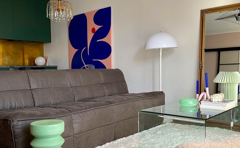 Wnętrze salonu z brązową sofą, zielonym stolikiem i nowoczesnymi akcentami.