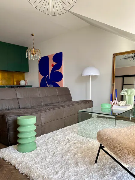 Wnętrze salonu z brązową sofą, zielonym stolikiem i nowoczesnymi akcentami.