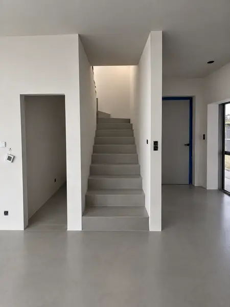 Nowoczesne wnętrze z białymi ścianami i szarymi schodami, styl art deco, minimalizm, industrialny.
