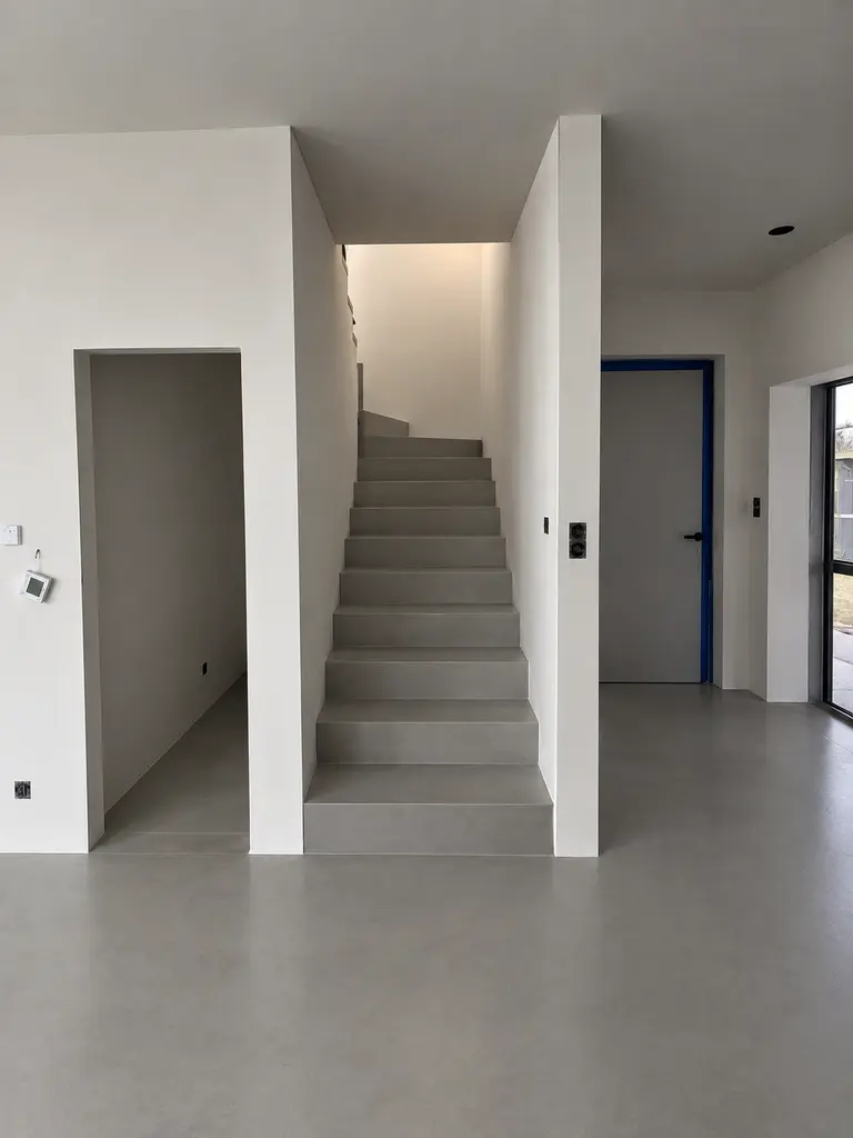 Nowoczesne wnętrze z białymi ścianami i szarymi schodami, styl art deco, minimalizm, industrialny.