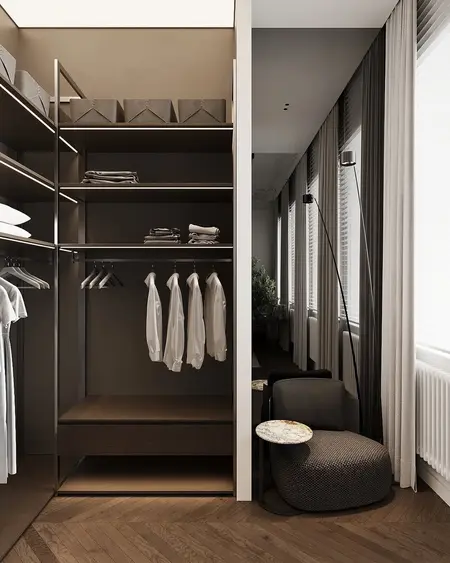 Garderoba minimalistyczna z drewnianymi półkami, nowoczesnym fotelem i dużymi oknami.