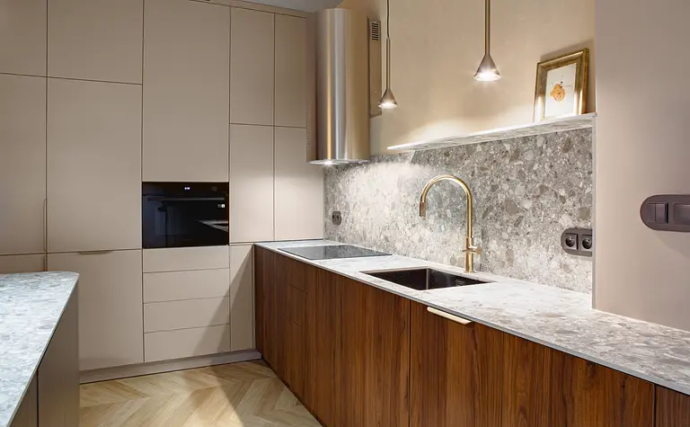 Nowoczesna kuchnia w stylu art deco i industrialnym z brązowymi meblami i marmurowym blatem.