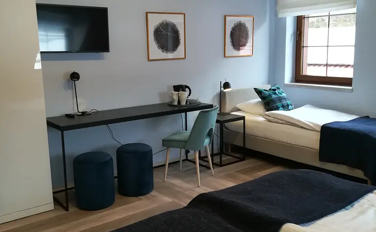 Pokój z minimalistycznym wystrojem, nowoczesnym biurkiem i współczesnym łóżkiem.