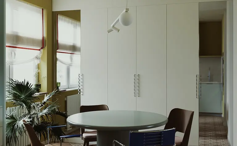 Wnętrze jadalni w stylu industrialnym i minimalistycznym z okrągłym stołem.