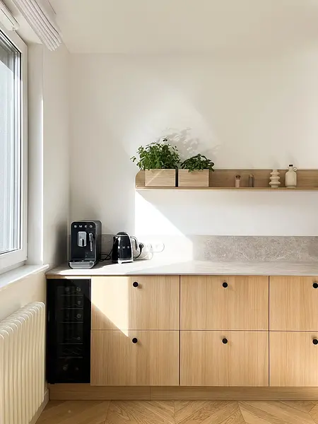 Kuchnia w stylu minimalistycznym, z drewnianymi meblami i roślinami.