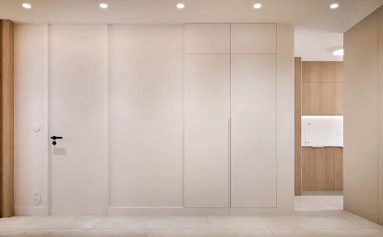 Wnętrze przedpokoju w stylu japandi, minimalistycznym i nowoczesnym z białymi i drewnianymi elementami.